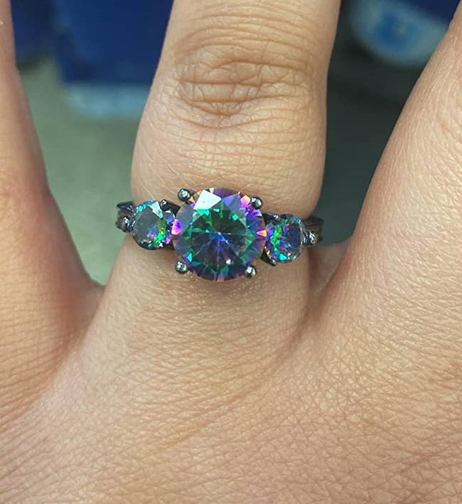 Reviewer photo of the topaz ring with green, purple, pink, and blue hues in all three stones