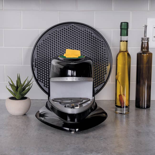 Butter dispenser connected  room  antagonistic  with works  and 3  decorative bottles successful  the background