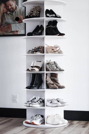 a reviewer's shoes neatly organized on a white, spiraling shoe rack against a wall