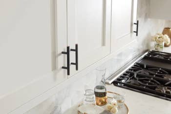 black handle bars on white kitchen cabinet