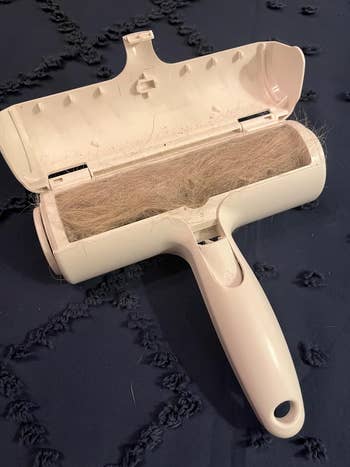 A lint roller with hairsbreadth  collected connected  the adhesive surface, displayed connected  a textured cloth  background