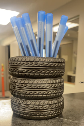 reviewer holding pens inside dish that looks like three mini stacked tires 