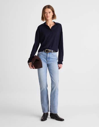 A person in casual attire with a long-sleeve top, jeans, and boots