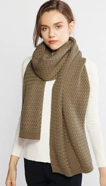 Woman wearing a white top with a textured brown scarf, ideal for a neutral, warm accessory