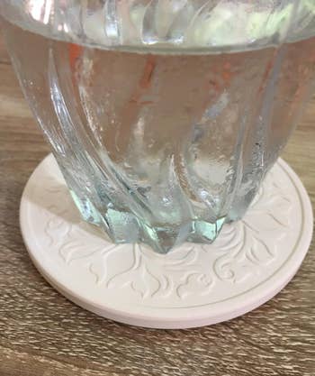 Glass cup with water droplets on a decorative coaster