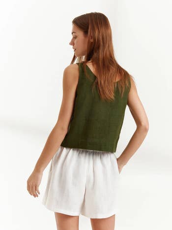 back of model wearing the green tank and white shorts