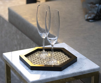 rattan tray used on side table with champagne flutes on it