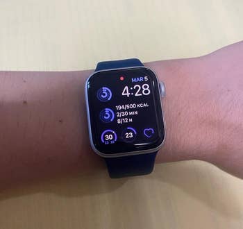 reviewer wearing watch showing health stats