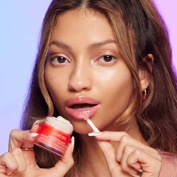model applying the peppermint lip mask to their lips using an applicator