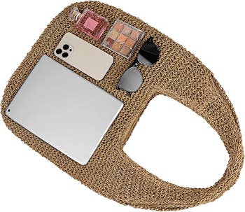 Straw woven tote bag displaying items: tablet, smartphone, sunglasses, perfume, and cosmetics. Ideal for stylish, on-the-go essentials