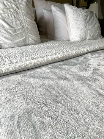 The blanket in light gray on a bed