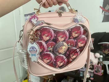 Heart-shaped bag adorned with anime character images and charms. Attractively designed for fans, perfect for anime-themed shopping