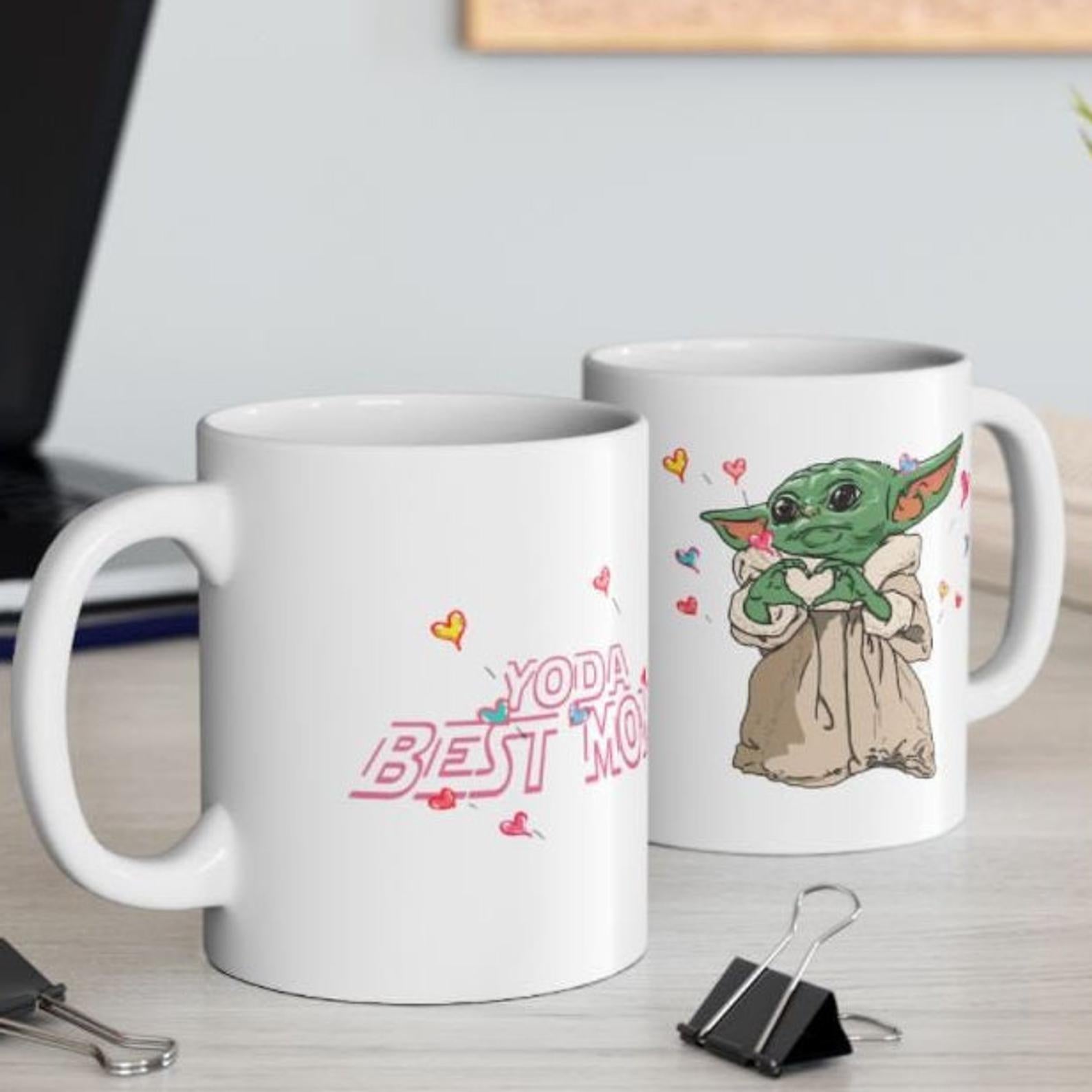 White mug that says Yoda Best Mom on one side and Baby Yoda making a heart gesture on the other 