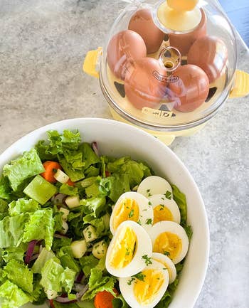 reviewer photo of yellow dash egg cooker next to a salad with eggs in it
