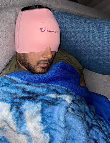 Reviewer asleep with pink mask wrapped around their hand 