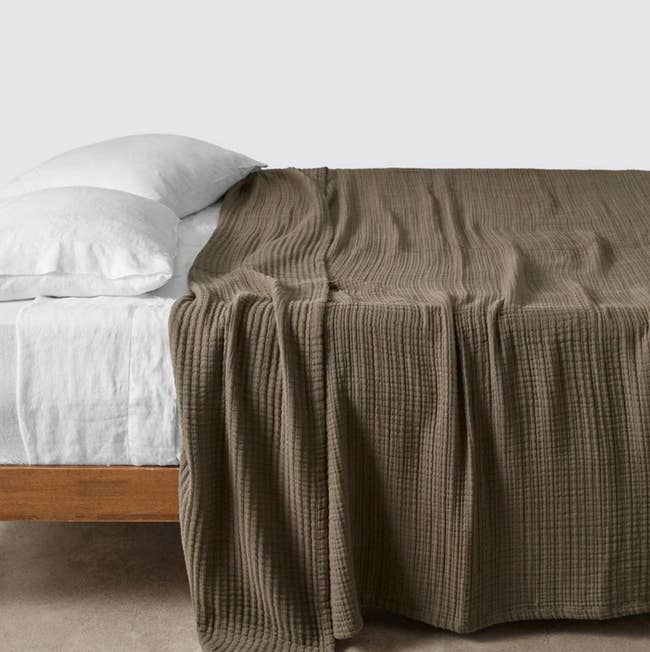 Bed with white pillows and a textured blanket invites relaxation; minimalist style perfect for enhancing a cozy bedroom aesthetic