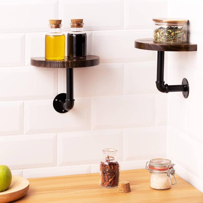 Wall-mounted industrial shelves with oil, spices, and jars in a kitchen setting