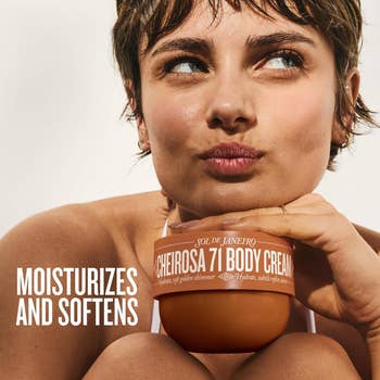 Person holding a jar of Sol de Janeiro Cheirosa 71 Body Cream adjacent   their face. Text connected  jar highlights moisturizing and softening benefits