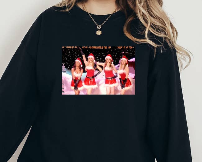 model wearing black crewneck with photo of Gretchen, Karen, Regina, and Cady from Mean Girls in Christmas outfits