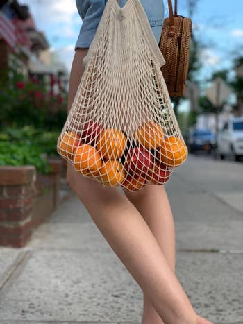 reviewer using the bag to carry fruits