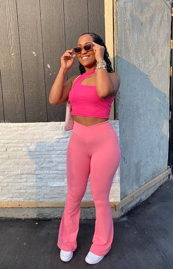 reviewer posing in pink flare yoga pants