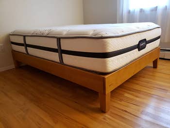 reviewer image of the rustic pine full size platform bed with a mattress on top