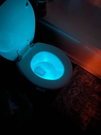 reviewer image of their toilet emanating blue light from the toilet night light