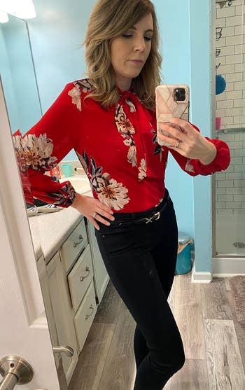 reviewer wearing the red floral blouse