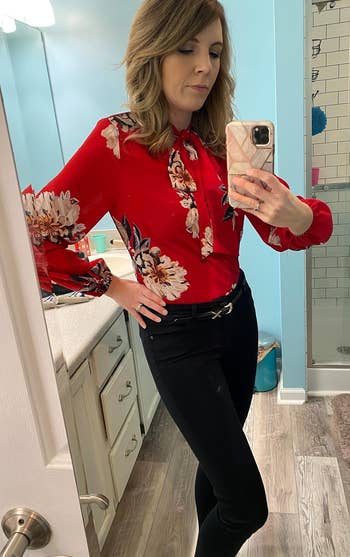 reviewer wearing the red floral blouse