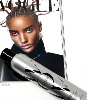 the silver bottle of hairspray laying on a Vogue magazine