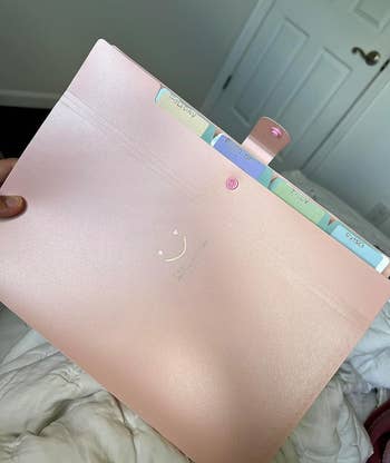 a reviewer holding the folder in light pink 