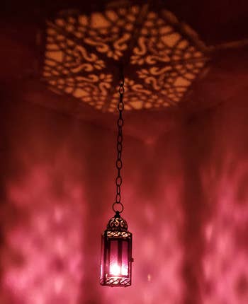 Hanging ornate lantern casting intricate shadows on the wall, adding ambiance for interior decor shopping articles