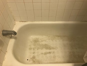 reviewer before image of a dirty and stained bathtub