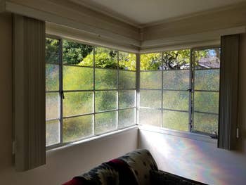 Privacy film applied to windows with sunlight streaming through