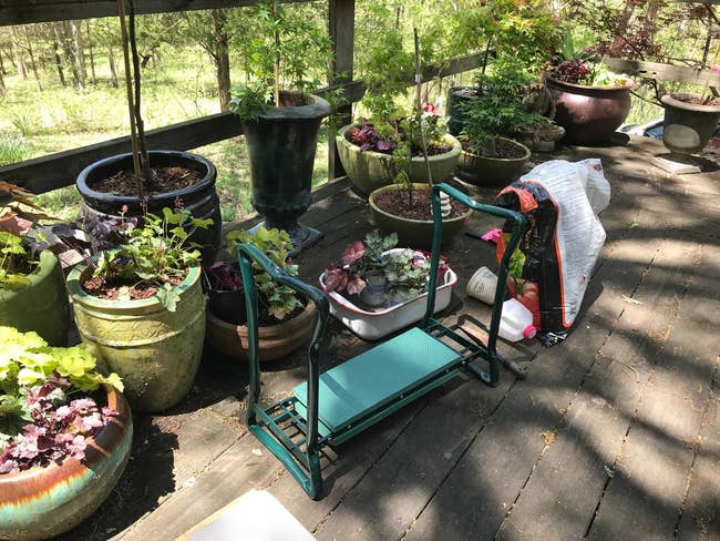 a kneeler bench for gardening next to potted plants