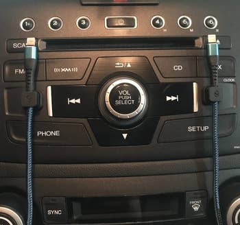 reviewer's car dash with two black magnetic clips on either side holding charging cables