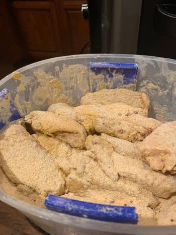 A container filled with breaded chicken strips, ready for cooking
