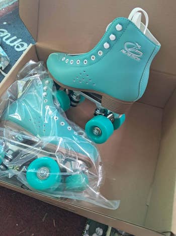 Roller skates successful a cardboard box, 1 brace wrapped successful plastic, featuring sturdy wheels and a sleek design