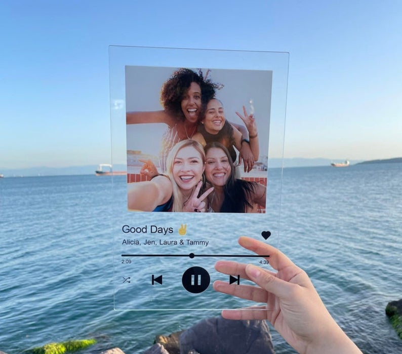 hand holding a music plaque which is clear and has the song 