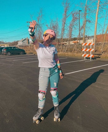 Writer is posing while wearing the protective gear and roller skates