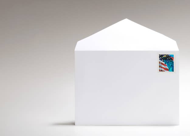 A sealed white business envelope with a U.S. postage stamp featuring the Statue of Liberty and the American flag in the top right corner