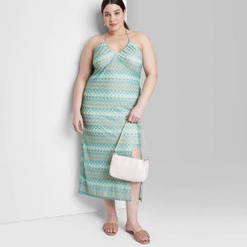 model in mint green tan and blue patterned crochet midi with slit