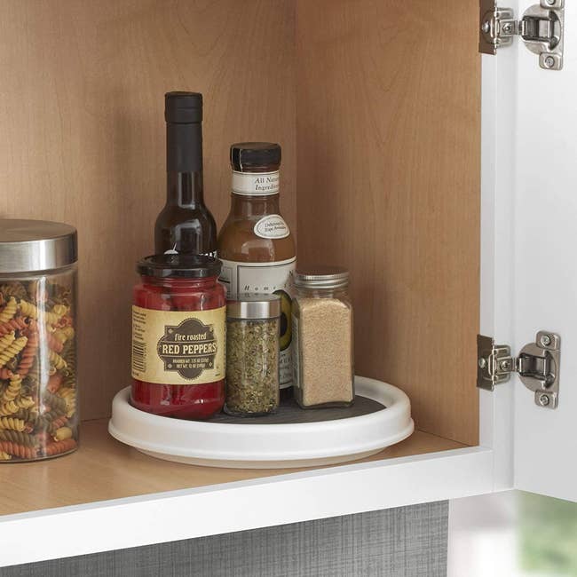 White lazy susan with rubber gripper in pantry with spices on it 