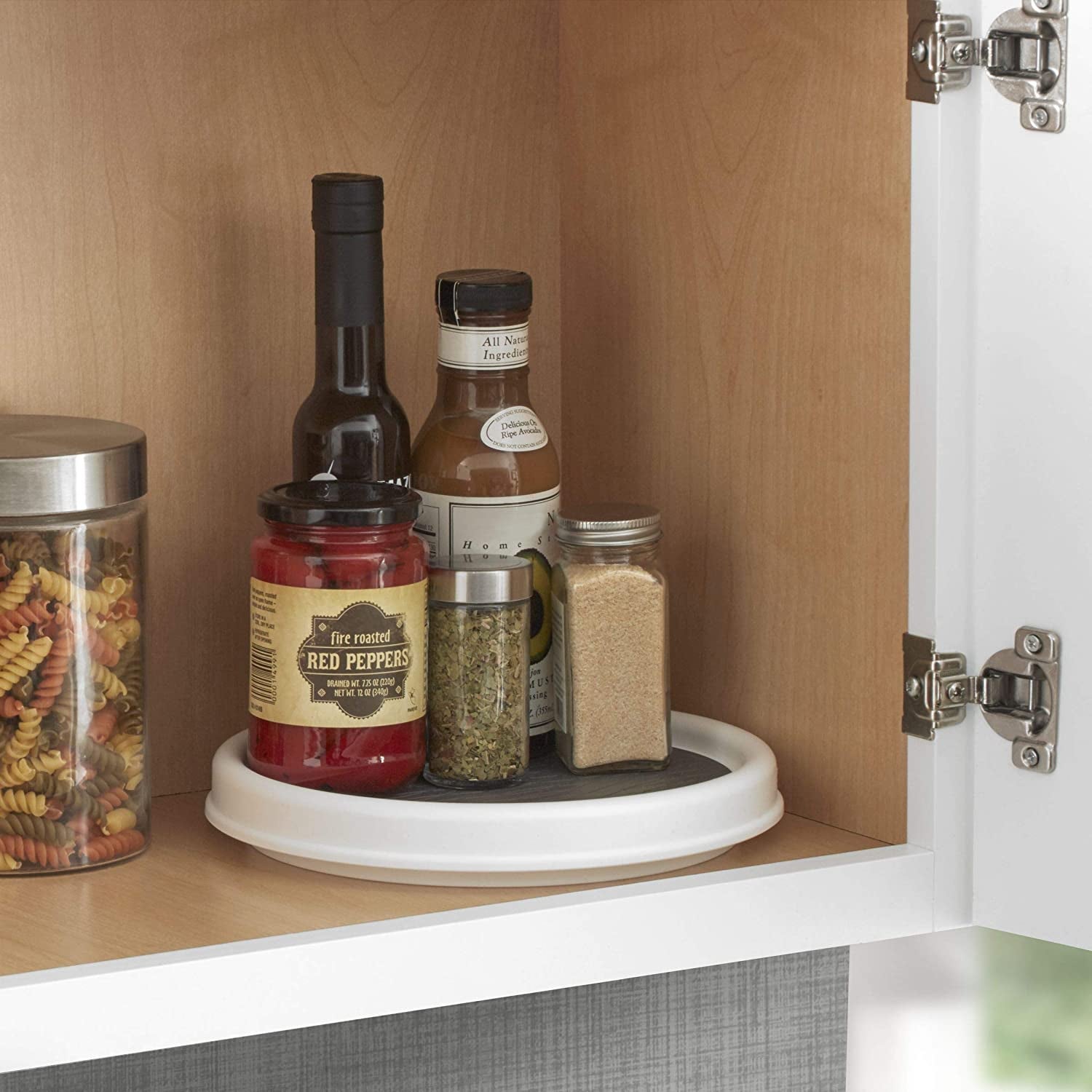 White lazy susan with rubber gripper in pantry with spices on it