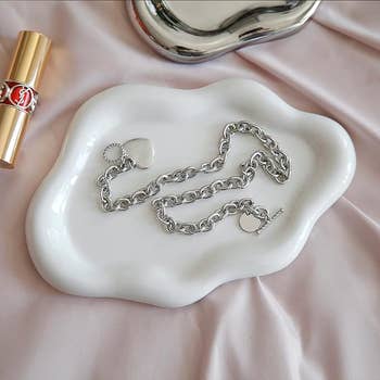 white cloud-shape tray holding silver jewelry