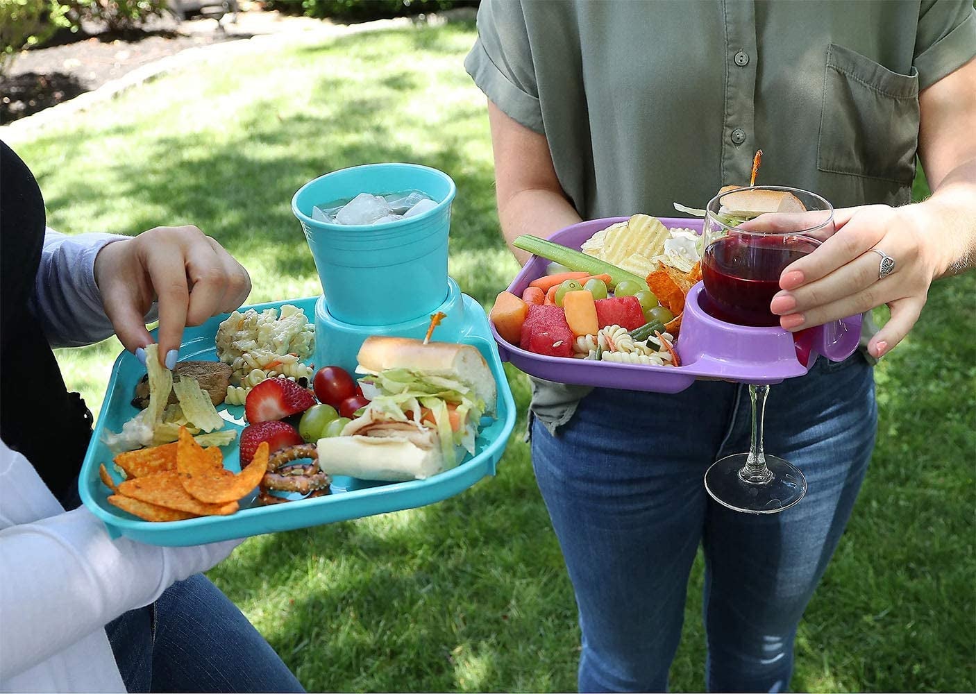 two people holding their plates with cups inside the cupholder 
