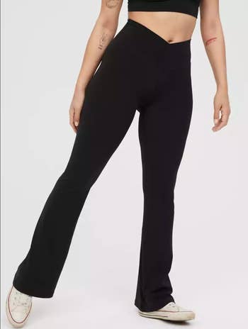 Model in a pair of black diagonal waist flared leggings 