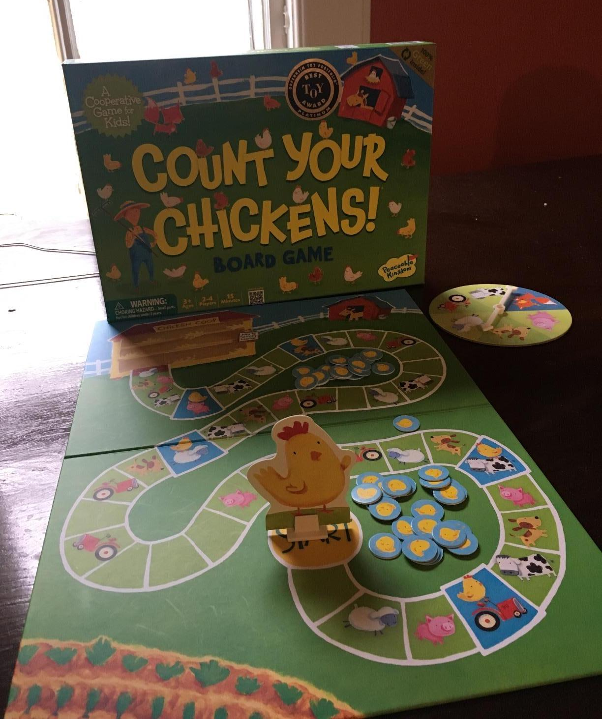 Reviewer image of farm-inspired game board with chicken and chick game pieces laid out