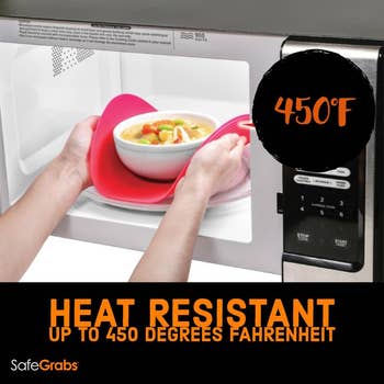 Person pulling out hot bowl from microwave with safe grabs