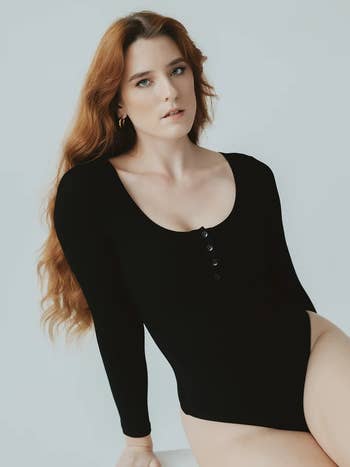 a model posing in the black bodysuit